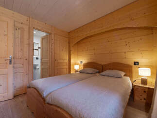 Experience rustic charm in this cozy wooden bedroom, featuring two comfortable twin beds perfect for a relaxing getaway.
