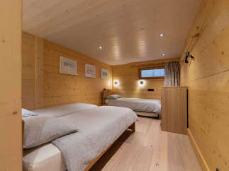 This charming wooden bedroom features two comfortable beds, perfect for accommodating guests.
