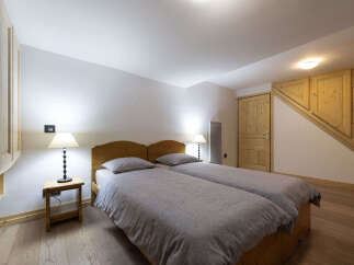 This charming bedroom features two comfortable twin beds dressed in soft grey linens, perfect for a restful night's sleep.