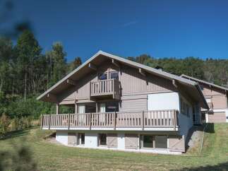 Discover this charming wooden chalet nestled amidst lush greenery, perfect for a serene mountain getaway.