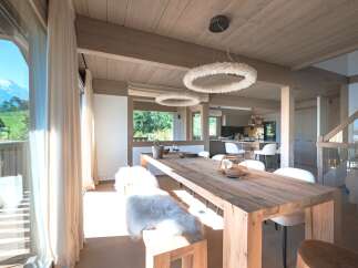 Experience luxurious mountain living in this stunning dining area, featuring a rustic wooden table and plush seating, perfect for gathering with loved ones.
