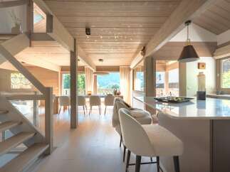 Experience luxurious mountain living in this stunning open-concept home, featuring a modern kitchen island with bar seating and a spacious dining area perfect for entertaining.
