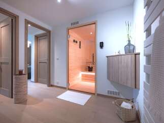 Experience ultimate relaxation in this modern spa area, featuring a beautifully crafted wooden sauna with glass doors.