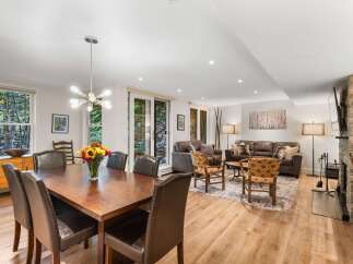Experience comfortable living in this spacious open-concept home, featuring a large dining area perfect for gatherings and a cozy living room with a stone fireplace.