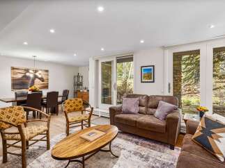 This inviting living and dining area features a cozy seating arrangement with a plush brown sofa and accent chairs, perfect for relaxation.