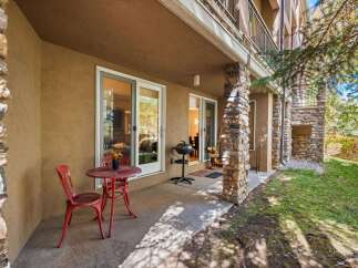 Enjoy outdoor living on this charming patio, complete with a red bistro set and a grill for al fresco dining.