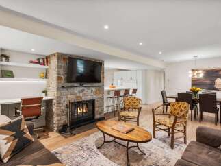 This inviting living space features a cozy stone fireplace as its centerpiece, perfect for gathering on chilly evenings.