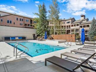 Enjoy a refreshing dip in the sparkling blue swimming pool, perfect for a sunny day.