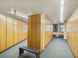 Discover a well-organized locker room featuring rows of light wood lockers, perfect for storing personal belongings.