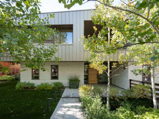 Discover modern living in this stunning home featuring a sleek metal facade and expansive windows that invite natural light.