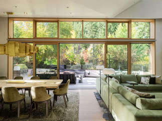 Experience seamless indoor-outdoor living in this stunning modern home, featuring expansive floor-to-ceiling windows that showcase breathtaking forest views.