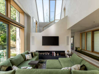 Experience modern living in this stunning home featuring a spacious open-concept living area with a large sectional sofa and a sleek fireplace.