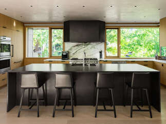 Experience modern luxury in this stunning kitchen, featuring sleek black cabinetry and a spacious island perfect for entertaining.