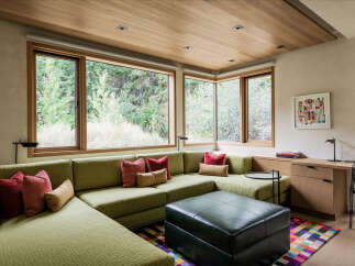 Experience modern living in this stunning home featuring a spacious sectional sofa and large windows that bring the outdoors in.