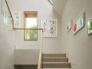 Ascend this beautifully designed staircase, featuring a natural wood handrail and glass balustrades, leading to a bright upper level.