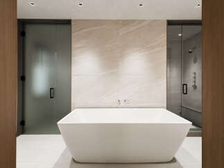 Experience modern luxury in this stunning bathroom featuring a freestanding soaking tub and a separate glass-enclosed shower.