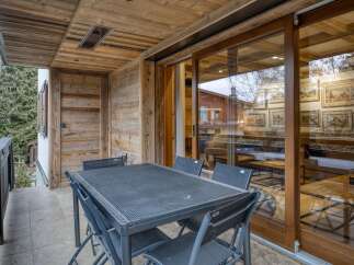 Enjoy al fresco dining on this charming balcony, complete with a table and chairs, perfect for enjoying the mountain air.