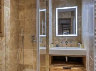 Experience luxury in this modern bathroom featuring a spacious walk-in shower with elegant stone tilework.