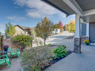 Enjoy the crisp autumn air from this inviting front porch, complete with a charming seating area and vibrant potted flowers.