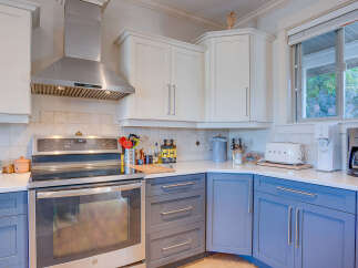 This modern kitchen boasts sleek stainless steel appliances, including a professional-grade range hood and a built-in oven.