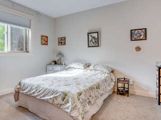 This charming bedroom features a comfortable queen-size bed adorned with a delicate floral comforter, perfect for a restful night's sleep.