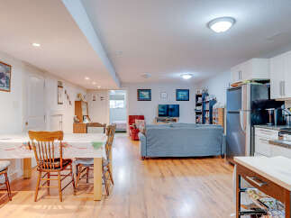 This spacious open-concept living area features a dining space with a charming table and chairs, perfect for family meals.