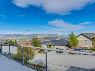 Enjoy breathtaking panoramic views from this stunning property, offering a picturesque backdrop of rolling hills and a vibrant blue sky.