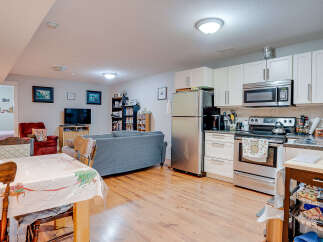 This open-concept living space features a fully equipped kitchen with stainless steel appliances and ample cabinet storage, seamlessly flowing into a comfortable living area.