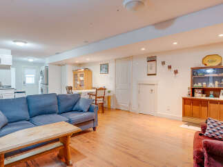 This spacious living area features a comfortable blue sofa and a rustic wooden coffee table, perfect for relaxing.