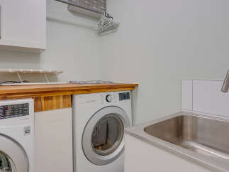 This laundry room boasts a spacious layout with two LG appliances, including a washer and a dryer, ready for your laundry needs.