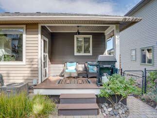 Enjoy outdoor living with this covered patio featuring comfortable seating and a grill, perfect for entertaining.