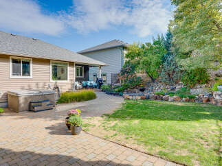 Enjoy outdoor living in this beautifully landscaped backyard featuring a spacious patio and a relaxing hot tub.