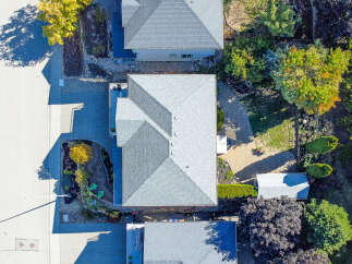 Discover this stunning aerial view showcasing a beautifully maintained property with a modern grey shingle roof.