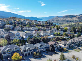 Discover this stunning collection of modern homes nestled on a picturesque hillside, offering breathtaking views of the serene lake and surrounding mountains.