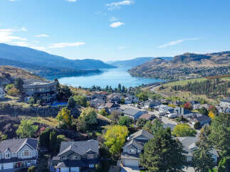 Experience breathtaking panoramic views of the serene lake and majestic mountains from this stunning hillside property.