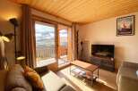 Experience breathtaking mountain views from this cozy living room, featuring a large sliding glass door that opens to a private balcony.