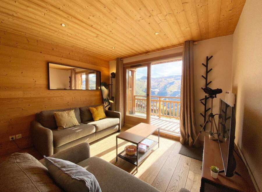 Experience cozy living in this charming mountain retreat, featuring warm wooden interiors and a spacious living area.
