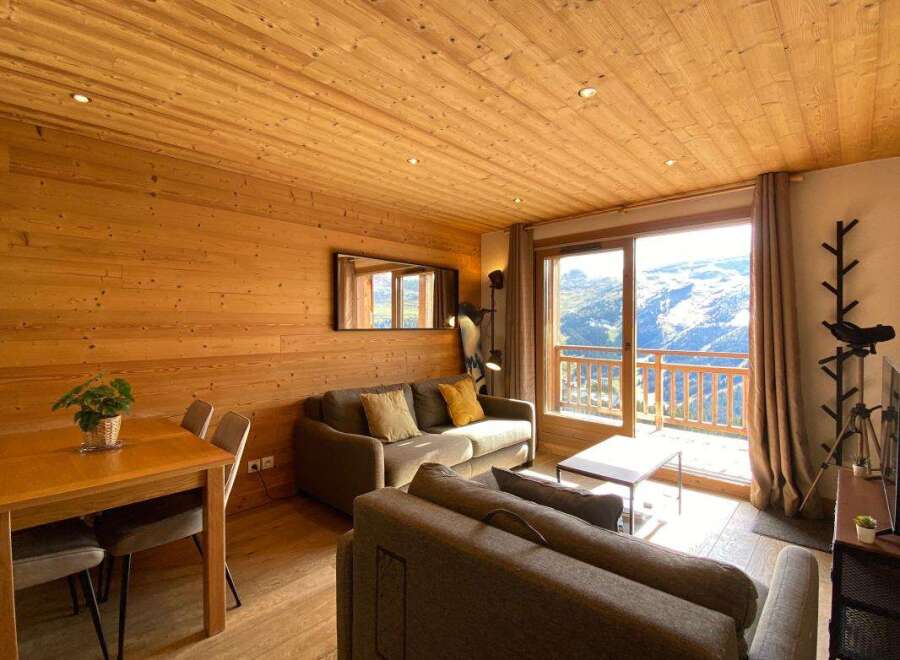 Experience breathtaking mountain views from this charming alpine retreat, featuring a cozy living area with a fireplace and a private balcony perfect for enjoying the scenery.