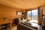 Experience breathtaking mountain views from this charming alpine retreat, featuring a cozy living area with a fireplace and a private balcony perfect for enjoying the scenery.
