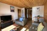 Experience the charm of this inviting living space, featuring a cozy seating area with plush sofas and a modern entertainment center.
