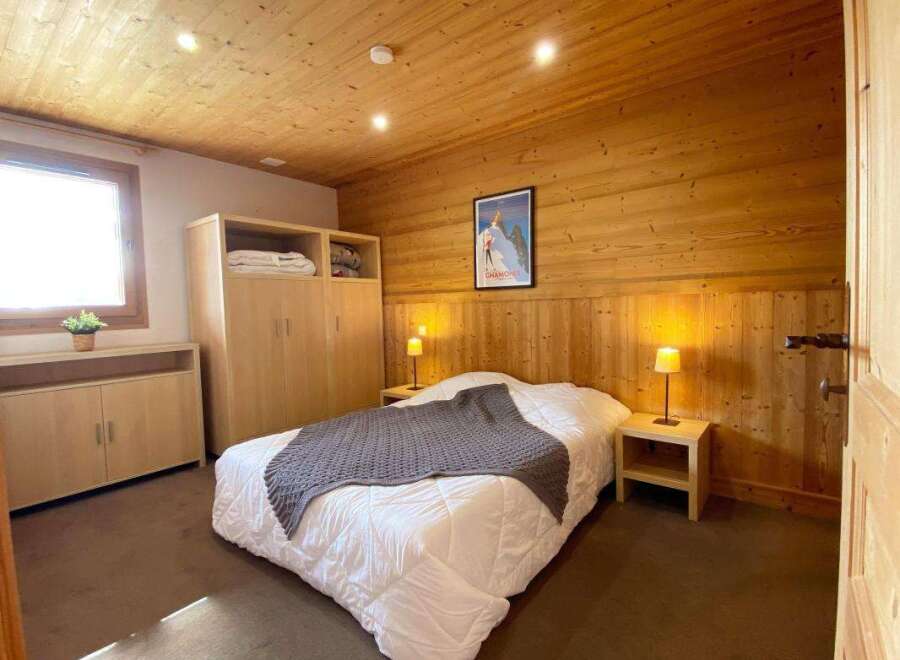 Experience cozy mountain living in this charming bedroom, featuring warm wooden walls and ceiling.