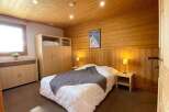 Experience cozy mountain living in this charming bedroom, featuring warm wooden walls and ceiling.