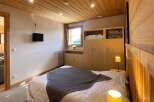 Experience cozy mountain living in this charming bedroom featuring a comfortable bed adorned with a plush grey throw.