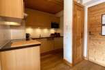 This charming kitchen features warm wooden cabinetry and a sleek countertop, perfect for meal preparation.