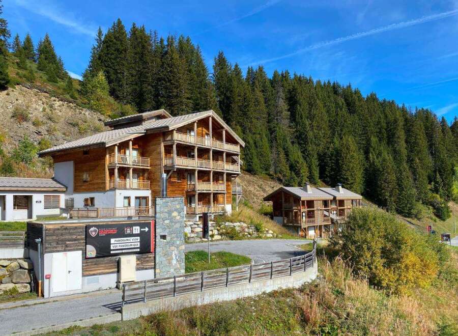 Discover this stunning multi-story wooden chalet nestled in a picturesque mountain landscape, perfect for a serene getaway.
