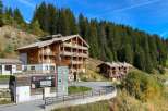 Discover this stunning multi-story wooden chalet nestled in a picturesque mountain landscape, perfect for a serene getaway.