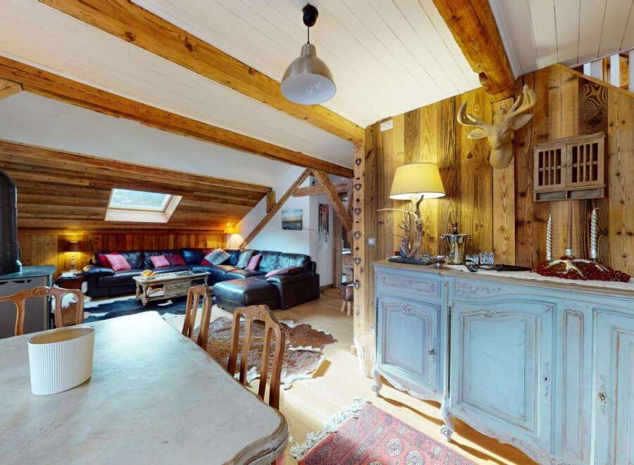 Experience rustic charm in this inviting living space, featuring exposed wooden beams and a cozy fireplace.