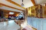 Experience rustic charm in this inviting living space, featuring exposed wooden beams and a cozy fireplace.