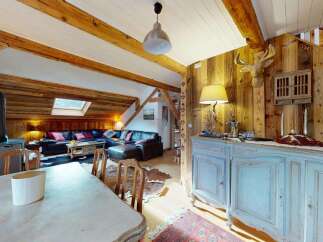 Experience rustic charm in this inviting living space, featuring exposed wooden beams and a cozy fireplace.
