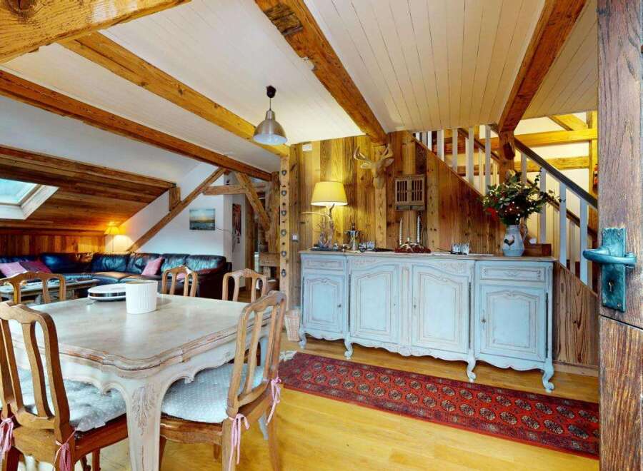 Experience rustic charm in this mountain retreat, featuring exposed wooden beams and a cozy living area with a fireplace.